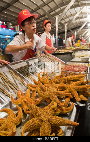 Exotische Speisen wie Seesterne und Insekten für den Verkauf von Ständen, Donghuamen Yeshi Nachtmarkt, Peking, China Stockfoto