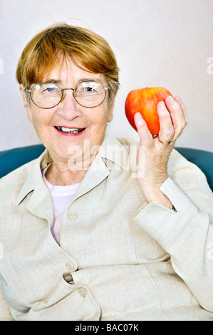 Ältere Frau Essen gesund hält einen nahrhaften Apfel Stockfoto
