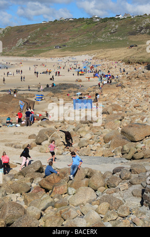 Sennen Cornwall Urlauber und Familien auf dem sandigen Strand und Felsen genießen einen sonnigen April Frühling Stockfoto