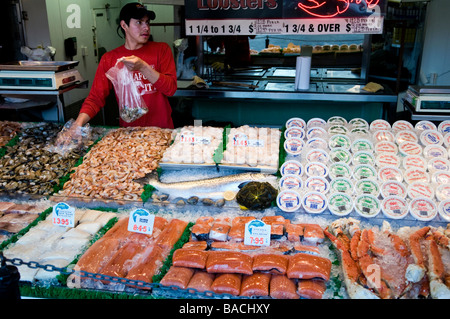 Ein junger Mann füllt ein Kundenauftrag am Kai in Washington DC, eine Open-Air-Fischmarkt. Stockfoto