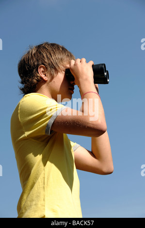 Jungen durch ein Fernglas suchen Stockfoto