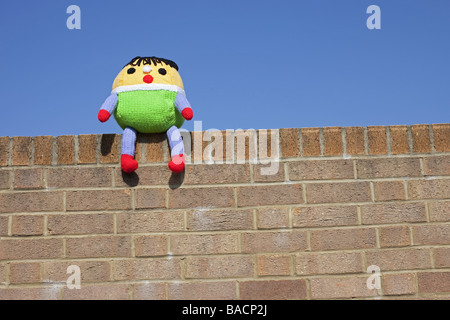 Ein Kuscheltier Humpty Dumpty saß auf der Wand mit einem blauen Himmelshintergrund. Stockfoto