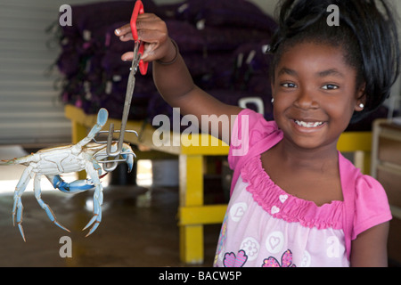 Werftgelände Louisiana ein Mädchen zeigt eine blaue Krabbe zum Verkauf an einem Straßenrand Fischmarkt Stockfoto