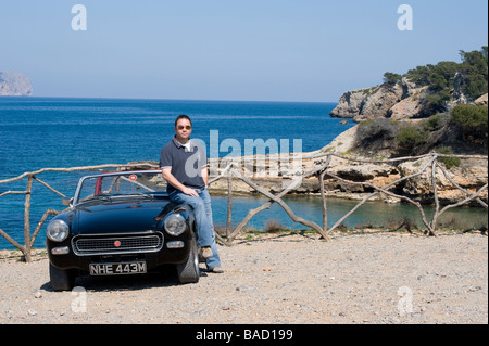 Mann mit seinem klassischen mg Midget Sportwagen in Mallorca Spanien Stockfoto