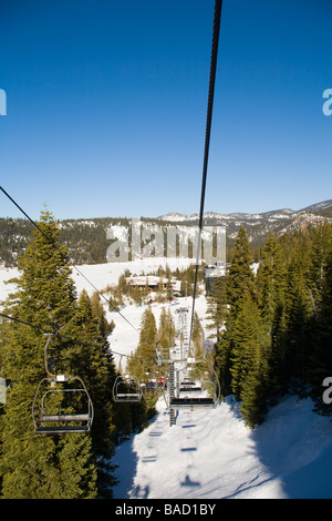 Olympic Valley, Kalifornien; Skifahrer am Sessellift mit Blick auf Squaw Creek in der Nähe von Lake Tahoe Stockfoto