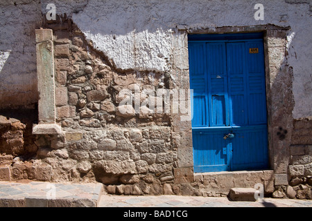 Eine bunte Tür kontrastiert mit der kombinierten Stile von Bau- und Renovierungsarbeiten in Cusco, Peru Stockfoto