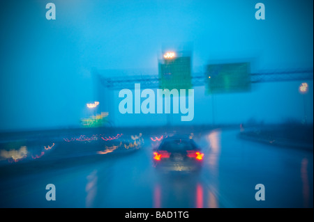 Ein Auto auf Regen nass Autobahn Landstraße Zeichen In Regen, Philadelphia, Pennsylvania, USA Stockfoto