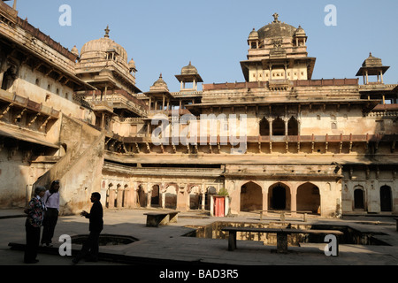 Ein lokaler Guide spricht mit Touristen im Innenhof des Jahangir Mahal (Palast) in Orchha. Stockfoto