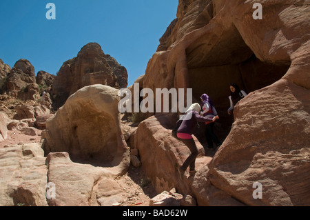 Eine Gruppe von jordanischen Schülerinnen Wandern in den Fels geschnitten Gräber am Eingang zu der antiken Stadt der Nabatäer von Petra Jordanien Stockfoto