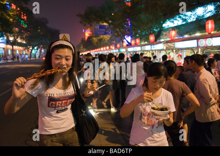 Stand-up Diner genießt gegrillte Langusten, Donghuamen Yeshi Nachtmarkt, Peking, China Stockfoto