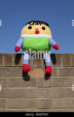 Ein Kuscheltier Humpty Dumpty saß auf der Wand mit einem blauen Himmelshintergrund. Stockfoto