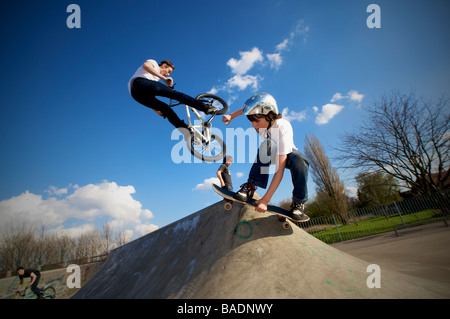 Männer in Aktion bei einem konkreten Skate-Park auf einem Skateboard und BMX Fahrrad Extremsport. Stockfoto