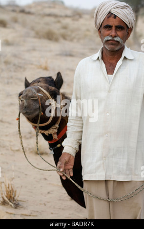 Rajasthani Mann mit seinem Kamel in der Thar Wüsten in der Nähe von Bikaner, Indien Stockfoto