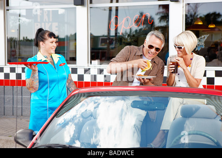 Kellnerin serviert paar in ihrem Cabrio in einem Retro-Diner, Niagara Falls, Ontario, Kanada Stockfoto