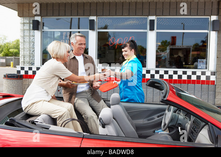 Kellnerin serviert paar in ihrem Cabrio in einem Retro-Diner, Niagara Falls, Ontario, Kanada Stockfoto