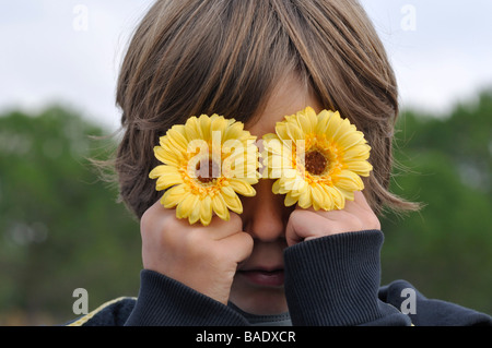 Junge mit Blumen über Augen Stockfoto