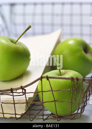 Grüne Äpfel und Umschläge im Draht-Tray Stockfoto