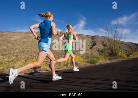 Frau läuft auf asphaltierte Straße, Saguaro National Park, Tucson, Arizona, USA Stockfoto
