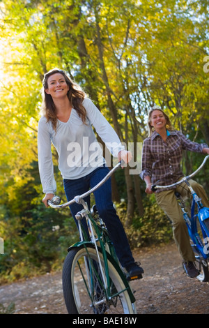 Zwei Frauen auf Fahrrädern durch Wald Stockfoto