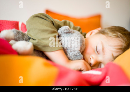 Jungen schlafen Stofftier mit gedrückter Stockfoto