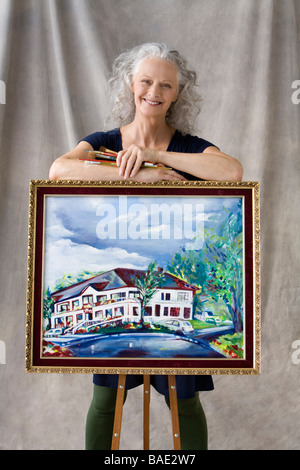 Porträt der Frau posiert mit Malerei Stockfoto