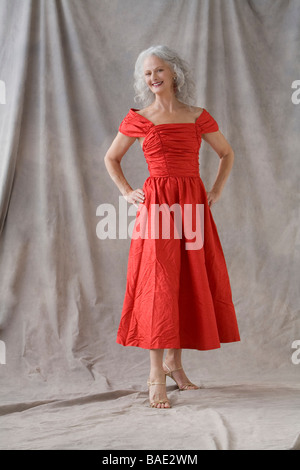 Reife Frau mit rotem Kleid Stockfoto