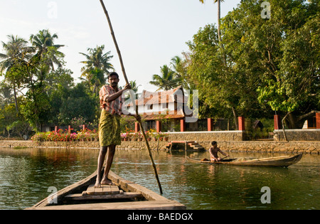 Fährmann punting ein "vallam" (Land Boot), die Gäste über zu Philippkutty's Farm eine intelligente Gastfamilie und Gewürzfarm auf Kerala's Backwaters, Indien Stockfoto