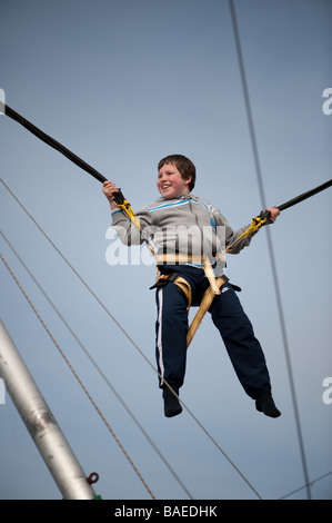 glücklich lächelnden jungen Kind auf dem Bungee-Trampolin auf Aberystwyth Promenade Frühling Nachmittag Stockfoto