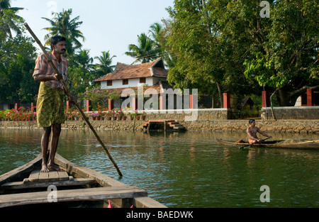 Fährmann punting ein "vallam" (Land Boot), um Gäste über zu Philipkutty Farm eine intelligente Gastfamilie, Backwaters, Kottayam District, Kerala, Indien zu nehmen Stockfoto