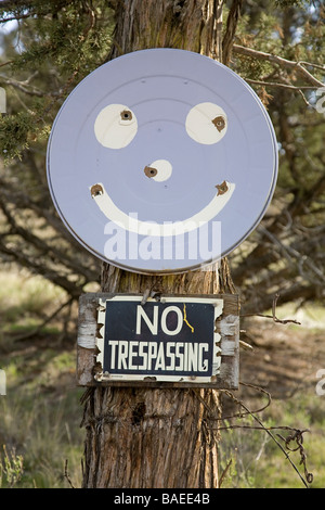 USA OREGON CROOKED RIVER VALLEY A No Trespassing Zeichen und ein Smiley-Gesicht mit Einschusslöchern Stockfoto