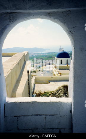 Blick auf Kirche und die umliegende Landschaft von Pyrgos, eingerahmt durch einen Bogen auf Santorini, Cyclades, griechische Inseln, Griechenland Stockfoto
