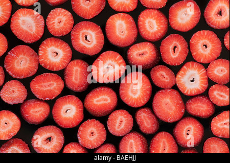 Fragaria Rosengewächse. Scheiben von Erdbeeren auf einem schwarzen Hintergrund Stockfoto