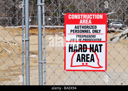 Baustelle Warnschild Schutzhelm Bereich autorisiertes Personal nur Eindringlinge werden auf einem Maschendrahtzaun strafrechtlich verfolgt werden. Stockfoto