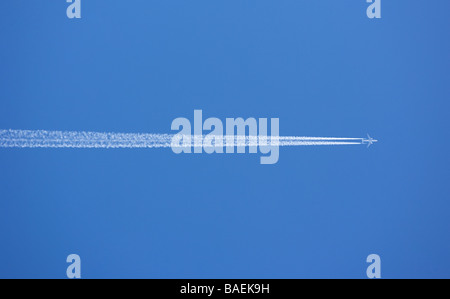 Ein Passagierflugzeug Jet fliegen in großer Höhe mit Kondensstreifen sichtbar vor einem strahlend blauen Himmel. Stockfoto