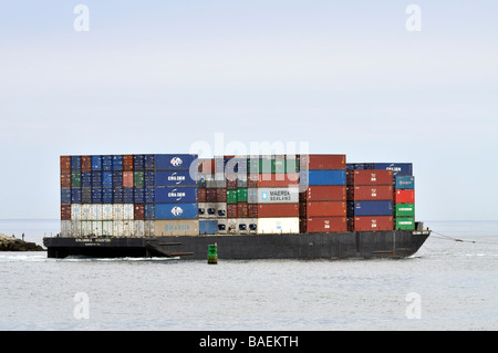 Barge am Meer mit Metall Container übereinander gestapelt geladen Stockfoto