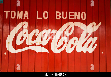 Mexiko Todos Santos Werbung für Coca Cola in spanischer Sprache gemalt auf der roten Holzgebäude Toma lo Bueno Motto Stockfoto