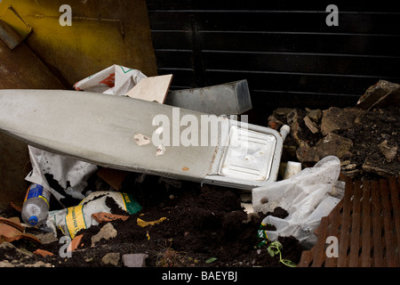 Ein Bügeleisen /-Brett in ein überspringen voller Baumaterialien geworfen Stockfoto