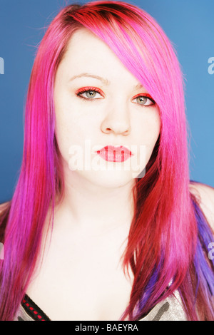 Junge Teen mit leuchtend rosa Haaren und roten Lippen Blick direkt in die Kamera Stockfoto