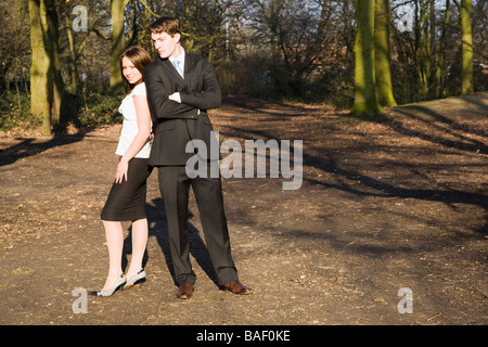 2 junge Geschäftsleute in den Wäldern suchen glücklich stehen Rücken an Rücken Stockfoto