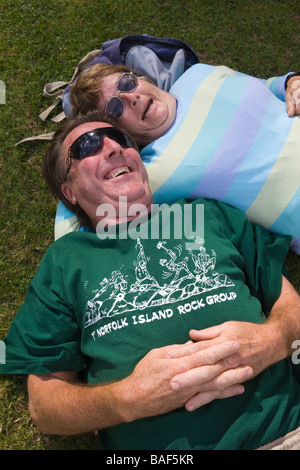 Paar, entspannend, lachend auf Rasen Detail Stockfoto