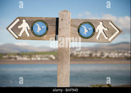 Ein hölzerner Wegweiser auf dem küstennahen Fußweg entlang der Küste der Isle of Anglesey Gwynedd Nord-Wales Frühling Nachmittag Stockfoto