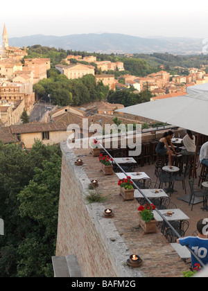 Eine Bar mit einem unschlagbaren Blick auf Perugia ist gefüllt mit mehreren Tabellen von Paaren. Stockfoto