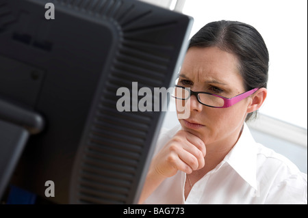 weibliche Büroangestellte Blick auf Computer-monitor Stockfoto
