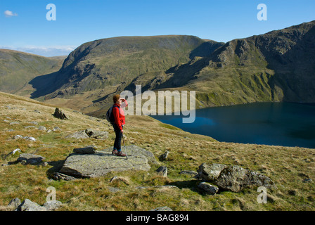 Weibliche Walker Blick über Blea Wasser, in der Nähe von Haweswater, Lake Districty Nationalpark, Cumbria, England UK Stockfoto