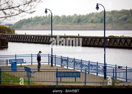 Einsamer Teenager geht auf das Geländer über den Fluss Mersey betrachtet seine Probleme Stockfoto