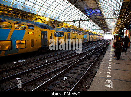 Menschen warten auf die Plattform von der Central Railway Station von Amsterdam, Niederlande Stockfoto