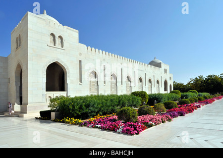 Gepflegter farbenfroher Garten und atemberaubende moderne islamische Architektur in der Sultan Qaboos Muscat Oman Grand Moschee polierter weißer Marmor, der sonnigen Tag pflastert Stockfoto