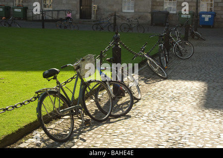 Traditionelle Fahrräder gesperrt gegen Kette Zaun am Trinity College in Dublin, Irland Stockfoto