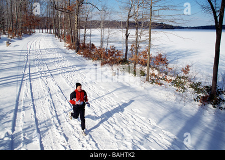 Jogger laufen im Schnee rund um Lake Scranton Scranton Pennsylvania USA Stockfoto