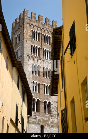 Einem gezahnten Turm erblickt zwischen Gebäuden in der Seitenstraße von Lucca, Toskana, Italien. Stockfoto